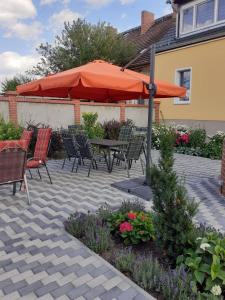 a patio with a table and chairs and an umbrella at Ferienwohnungen Kusche in Stennewitz