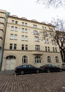 two cars parked in front of a building at Capsule hostel Andel Centre SPIRIT in Prague