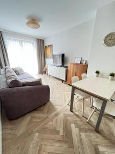 a living room with a couch and a table at Apartament Śnieżny in Karpacz