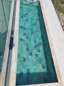 uma piscina de mosaicos no topo de um edifício em Apartman Casa em Trebinje