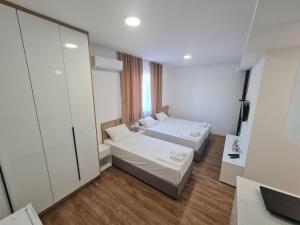 um pequeno quarto com 2 camas e um espelho em Apartman Casa em Trebinje