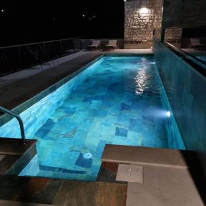 uma piscina à noite com água azul em Apartman Casa em Trebinje