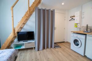 een kamer met een bed, een tv en een trap bij Studio duplex, proche université in Montbéliard