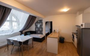 プラハにあるAndel Centre SPIRITの小さなキッチン、テーブルと椅子が備わる小さなアパートメントです。