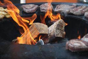 een grill met een hoop vlees en vlammen bij B&B Schoonhoven Suites in Elim