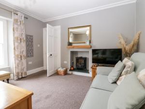 a living room with a couch and a television at Cartmel Flat in Grange Over Sands