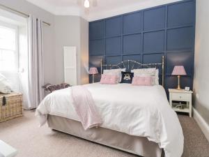 a bedroom with a large bed with a blue headboard at Cartmel Flat in Grange Over Sands