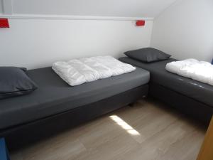 two beds sitting next to each other in a room at Kustverhuur, Vakantiepark Fort Soleil 26 in Breskens