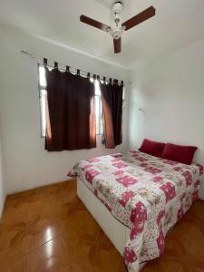 een slaapkamer met een bed en een plafondventilator bij Pousada 146 in Campos dos Goytacazes