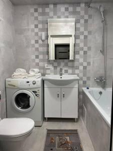 a bathroom with a washing machine and a sink at Hotel Confort Drochia in Drochia
