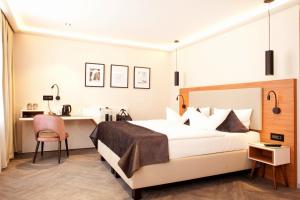 ein Hotelzimmer mit einem Bett und einem Schreibtisch in der Unterkunft Hotel Schweriner Hof in Stralsund