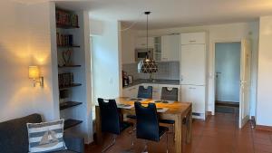 a kitchen and dining room with a table and chairs at Feriendorf Rugana Insel Rügen Fewos Vogelgesang in Dranske