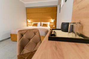 a hotel room with a bed and a desk at Pensiunea Elisei in Timişoara