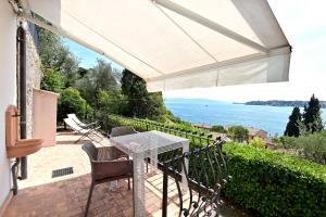 a patio with a table and chairs and a view of the water at Villa Raoul in Salò