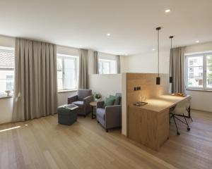 a living room with a table and chairs and a kitchen at Küchlinhaus in Memmingen