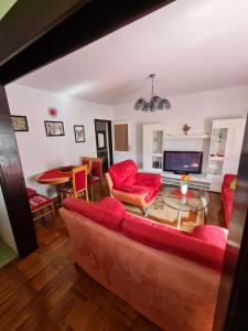 a living room with a red couch and a table at Horizont apartmans in Jajce