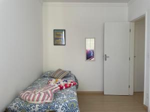 a bedroom with a bed and two pictures on the wall at Apartamento Acolhedor e Bem Localizado in Vila Velha