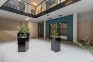 a hallway with two potted plants in a building at Deluxe City Studio with Parking Kącik 10 by Renters in Krakow