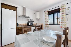a kitchen with a table and a white refrigerator at Novobarrosa D in Chiclana de la Frontera