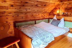 een slaapkamer met een bed in een blokhut bij Idyllische Zirbenholz Alpin Huette in Turracher Höhe