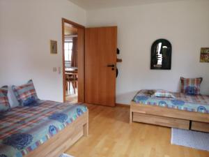 1 dormitorio con 2 camas y puerta de madera en Ferienhaus Nienaber, en Grafenau