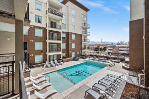 an apartment patio with a swimming pool and lounge chairs at Luxurious Retreat in SLC in Salt Lake City