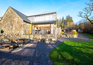 a stone building with a picnic table in front of it at Beudyr Gelli in Trawsfynydd