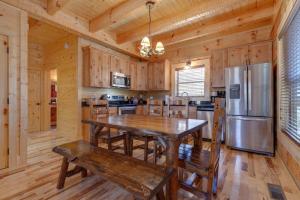 a large kitchen with a table and a refrigerator at Lovers' Hideaway, 1 Bedroom, Jetted Tub, Private, Pool Table, Sleeps 4 in Gatlinburg