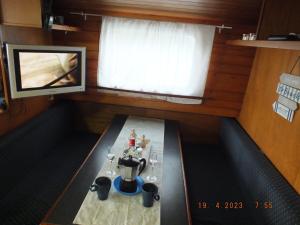 een kleine kamer met een tafel en een televisie bij Zouw Hausboat Zakotven -pouze ubytovaní in Roudnice nad Labem
