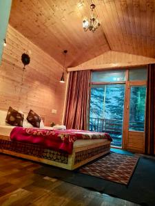 a large bed in a room with a window at WildWoodHome Jibhi in Jibhi