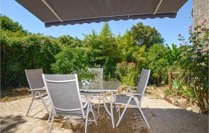 un tavolo e delle sedie seduti su un patio di Awesome Home In Petreto Bicchisano a Petreto-Bicchisano