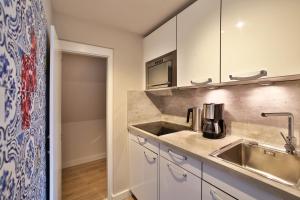 a kitchen with a sink and a microwave at Apartmenthaus Budersandstraße 53 in Hörnum