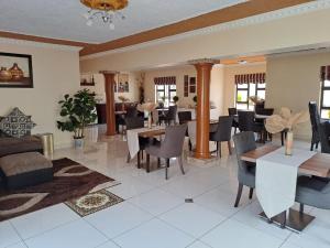 uma sala de jantar com mesas e cadeiras num quarto em Ecotel OR Tambo Airport em Kempton Park