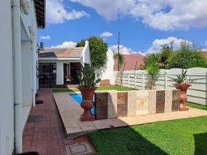 a backyard with a fence and a swimming pool at Ecotel OR Tambo Airport in Kempton Park