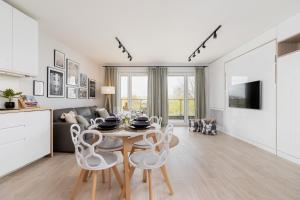 a kitchen and living room with a table and chairs at Deluxe City Studio with Parking Kącik 10 by Renters in Krakow