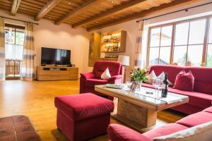 a living room with red furniture and a tv at Ferienhaus Eva inkl. Chiemgaukarte in Ruhpolding