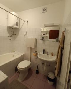 La salle de bains blanche est pourvue de toilettes et d'un lavabo. dans l'établissement Apartment SUNSET, à Omiš
