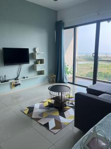 a living room with a couch and a large window at Atlantis Sea View Unit in Malacca