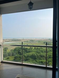 a room with a large window with a view of trees at Atlantis Sea View Unit in Malacca