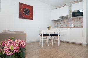 - une cuisine avec une table et des chaises dans la chambre dans l'établissement Villanova Apartment, à Cagliari