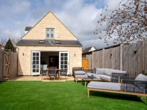 a backyard with a couch and chairs on a lawn at Pass the Keys Town Centre cottage with garden and parking in Cheltenham