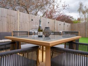 a wooden table with a bottle of wine and two glasses at Pass the Keys Town Centre cottage with garden and parking in Cheltenham