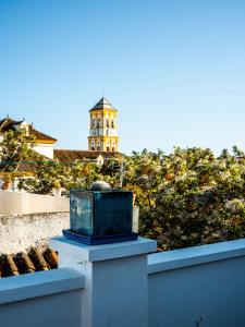 a blue box sitting on a wall with a lighthouse in the background at Castillo de Marbella in Marbella