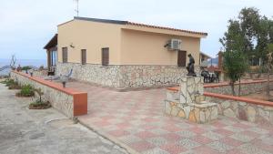 ein Haus mit einer Steinmauer und einer Statue in der Unterkunft Villa Delia in Balestrate