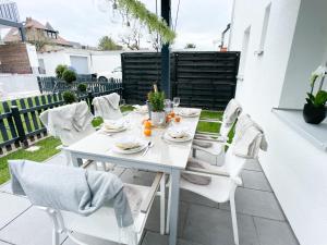 una mesa blanca y sillas en un patio en M-Style 01 Apartment mit Terrasse und Gasgrill, 24h Self-Check-In, Free Parking, Netflix, en Núremberg