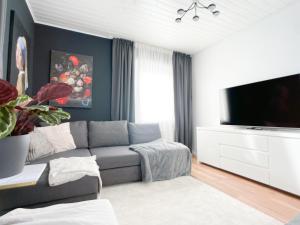 uma sala de estar com um sofá e uma televisão de ecrã plano em M-Style 01 Apartment mit Terrasse und Gasgrill, 24h Self-Check-In, Free Parking, Netflix em Nurembergue