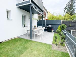 een patio met een tafel en stoelen in een tuin bij M-Style 01 Apartment mit Terrasse und Gasgrill, 24h Self-Check-In, Free Parking, Netflix in Neurenberg