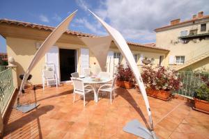 eine Terrasse mit einem Tisch und Stühlen auf dem Balkon in der Unterkunft Casa Sultana in Propriano