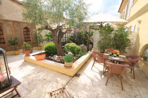 a courtyard with a tree and a table and chairs at Casa Sultana in Propriano