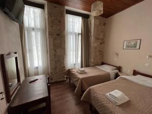 a hotel room with two beds and a mirror at Rethymno House in Rethymno Town